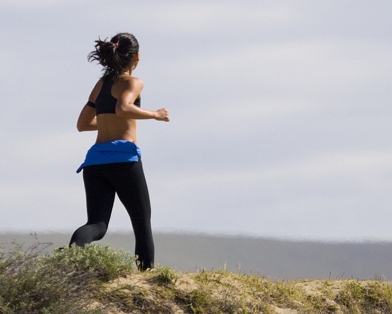 Woman jogging through long grass