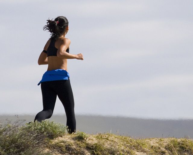 Woman jogging through long grass