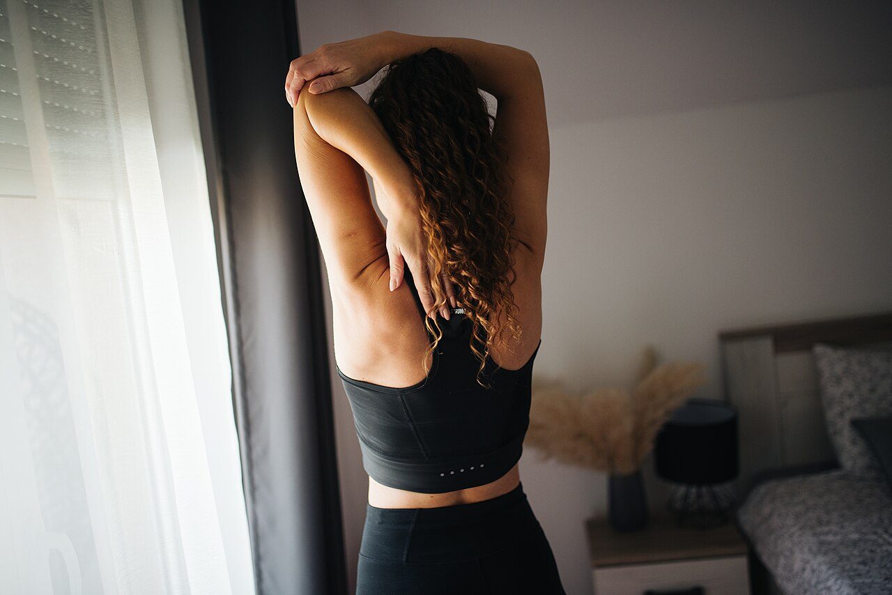 Woman seen from behind stretching her arms
