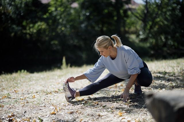 Woman stretching in a park before exercise