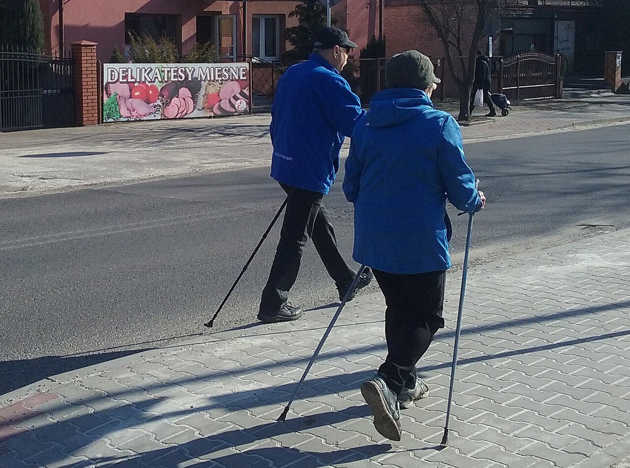Two people Nordic walking on a pavement