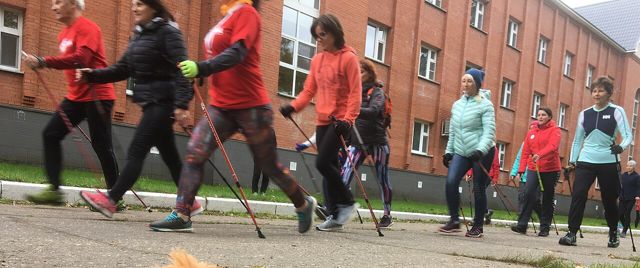 Group of people Nordic walking along a street