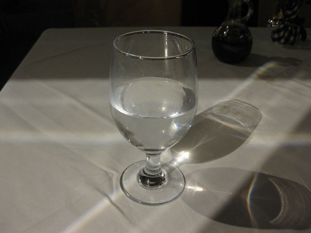 Glass of water on a table in sunlight